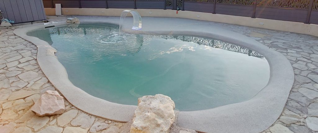 bassin d'une piscine lagon installer par Horizon Lagon avec cascade de piscine
